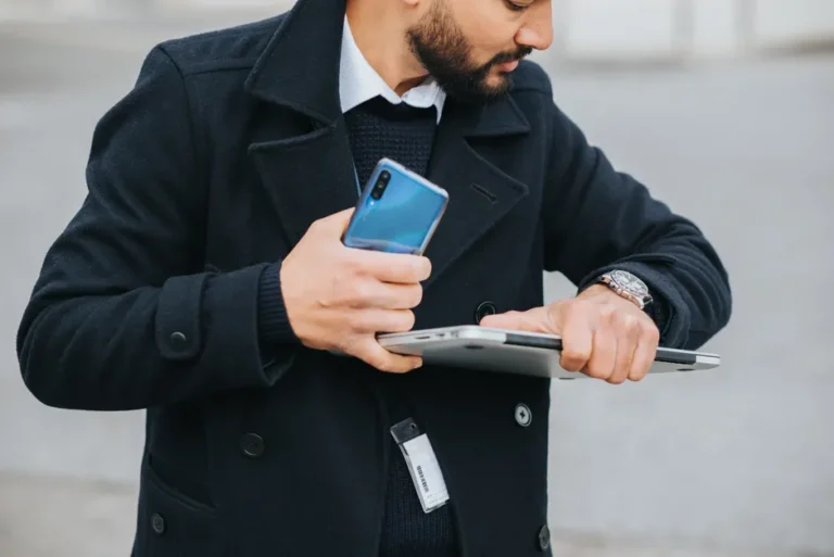 « Are You Dead? » : l’application iOS à 8 yuans qui alerte un proche Crop attentive ethnic male office worker in formal apparel with smartphone and laptop checking time on wristwatch in city
