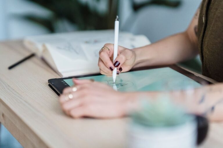 Safari perd Marco Triverio : The Browser Company annonce son arrivée le 7 janvier 2026 Crop unrecognizable female designer using tablet and stylus for drawing sketches on wooden table