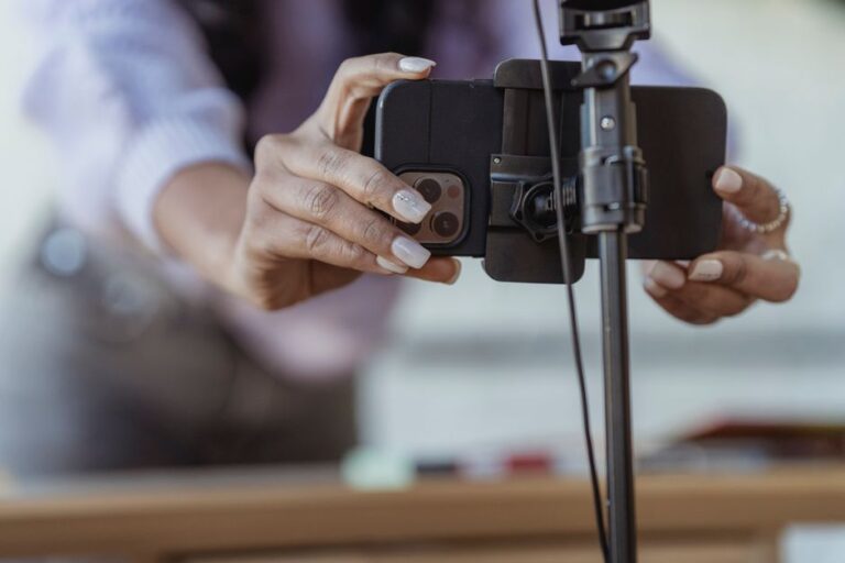Moft Trackable : trois accessoires MagSafe avec Find My dès 49 dollars au CES 2026 Crop unrecognizable female setting mobile phone on tripod while recording vlog on blurred background