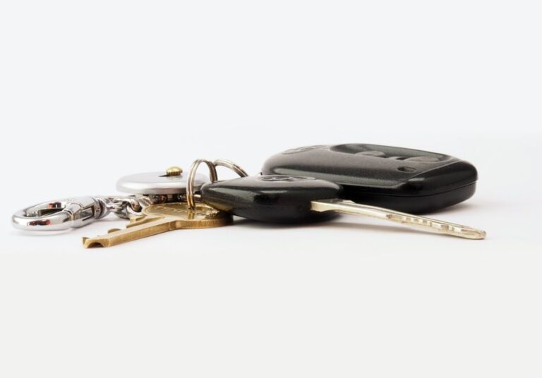 Nouvel AirTag lancé le 26 janvier 2026 : l’ancien modèle baisse Detailed image of car keys on a white surface, including a key fob and keychain.