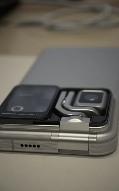 Detailed shot of a sleek foldable smartphone with dual camera module and shiny metallic finish.