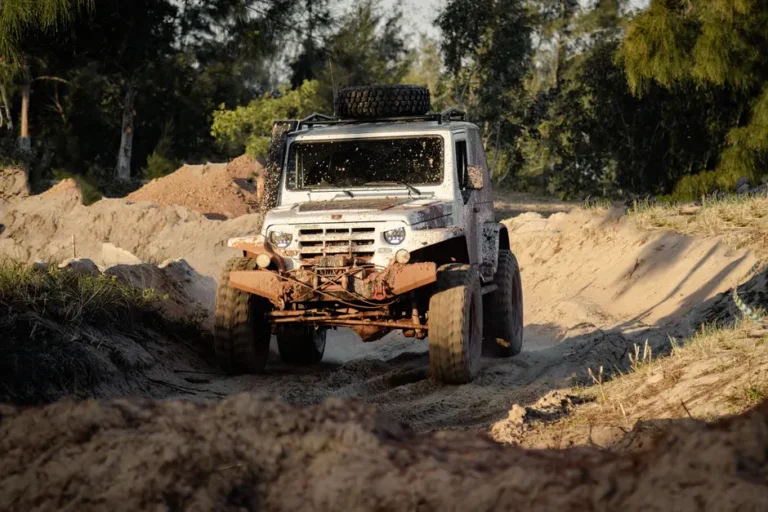 SnowRunner sur Mac : le contenu se fige après novembre 2025 Dynamic off-road driving adventure with a muddy white truck navigating through a desert terrain.
