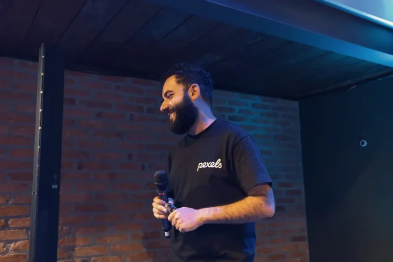 Apple en Formule 1 : Vision Pro prend le départ chez Red Bull en 2026 Engaging speaker at an indoor event with a microphone, wearing a Pexels shirt.