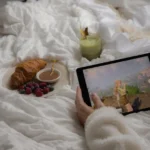 Enjoy a cozy morning in bed with a croissant, berries, matcha latte, and a tablet game.