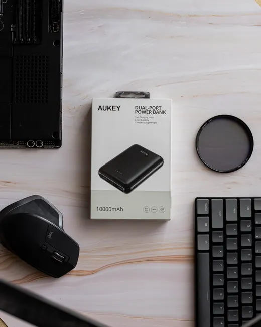 Flat lay of office gadgets, highlighting a dual-port power bank and accessories for efficient work setups.