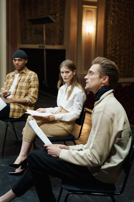 Group of actors engaging in a theater rehearsal indoors.