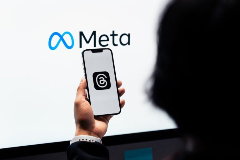 Meta teste ses abonnements premium en 2026, l’IA passe à la caisse Hands holding smartphone with Meta Threads logo on screen, Meta branding in background.