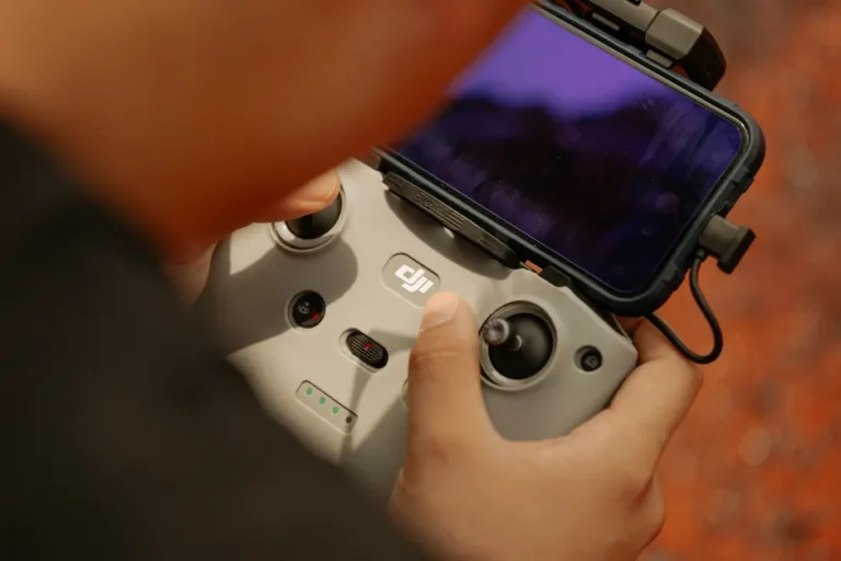 Hands using a modern drone controller with attached smartphone for scenic aerial views.