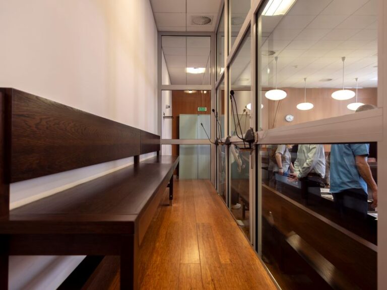 Apple face à 38 milliards de dollars en Inde : audience le 27 janvier 2026 Interior view of a courtroom in Wrocław, Poland, featuring wooden benches and glass partitions.