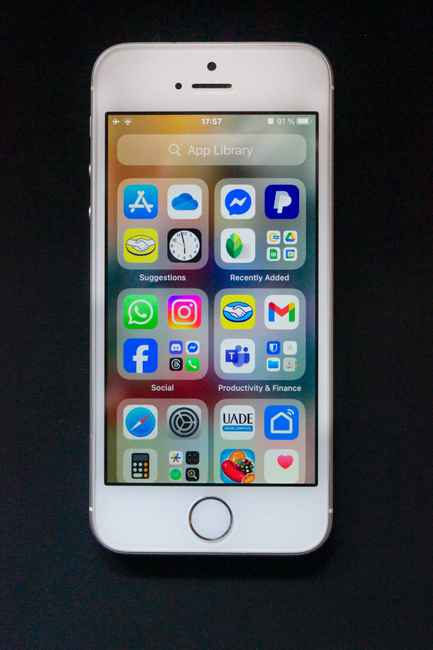 iPhone showing a home screen filled with various social media and app icons against a black background.