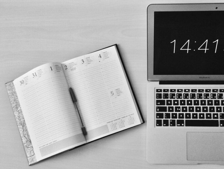MacBook Air M4 : 250 dollars de remise, le SSD tousse encore Minimalist office workspace with a notebook and MacBook Air showing 14:41 time.