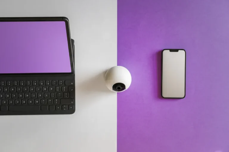 Continuity Camera : Reincubate poursuit Apple sur deux brevets en 2026 Minimalist setup featuring a tablet, smartphone, and spherical webcam on a split colored background.