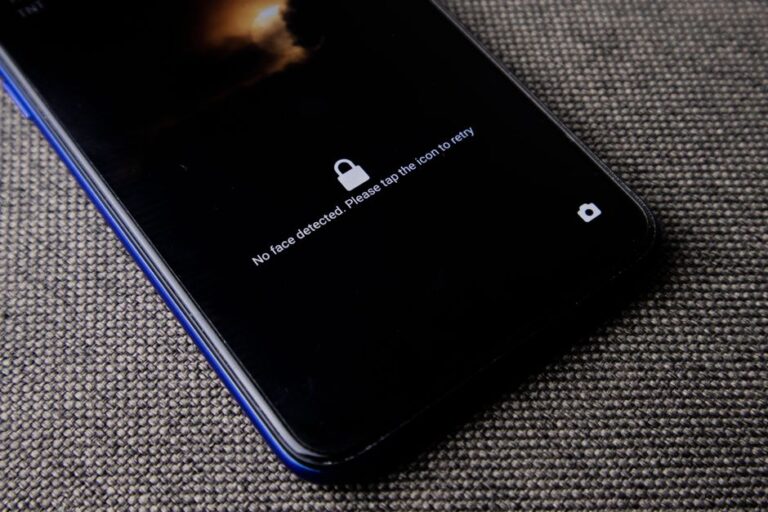 ChatGPT Apple Health depuis le 7 janvier 2026: la confidentialité tousse Mobile phone with no face detected message on lock screen on a textured fabric surface.