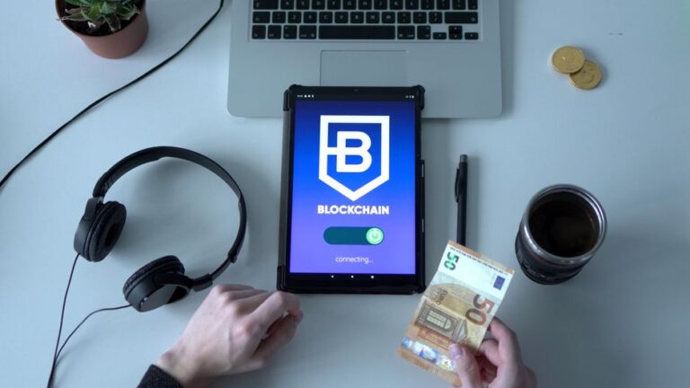 iPad et crypto : 3 millions sous pression, Apple au dossier Overhead view of digital tablet with blockchain app, cash, and tech tools on desk.