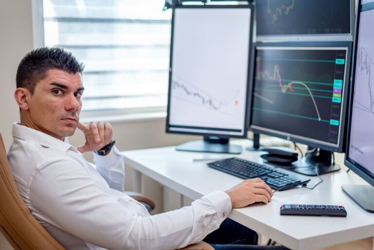 Apple à 315 dollars : JPMorgan mise sur l’iPhone 18, mais pas les yeux fermés Professional stock market analyst monitoring data on multiple screens at a workstation.