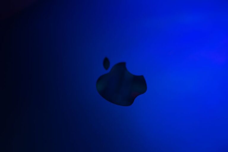 Apple, 1976-2026 : du logo Newton à la marque calibrée Silhouette of an apple logo against a blue gradient background, minimalistic design.