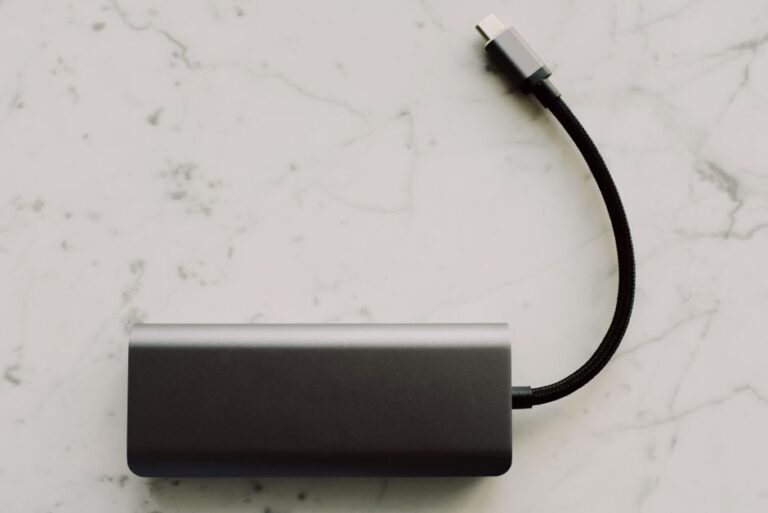 BMX au CES 2026 : 140 W, SSD 2 To et batteries fines, le prix attendra Sleek power bank with USB-C cable on a marble surface, ideal for travel tech needs.