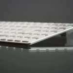 Keychron Q Ultra au CES 2026 : 660 heures et 8 kHz, la touche monte d'un cran Stylish close-up of a modern slim keyboard on a reflective surface, showcasing minimalist tech design.