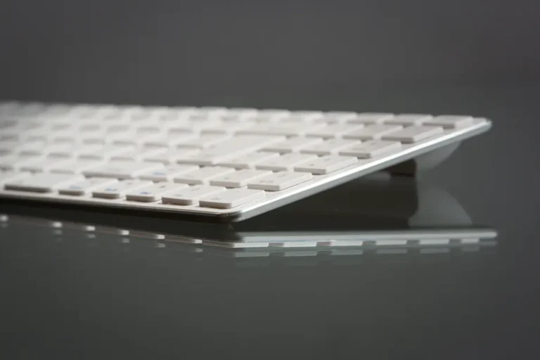 Keychron Q Ultra au CES 2026 : 660 heures et 8 kHz, la touche monte d’un cran Stylish close-up of a modern slim keyboard on a reflective surface, showcasing minimalist tech design.