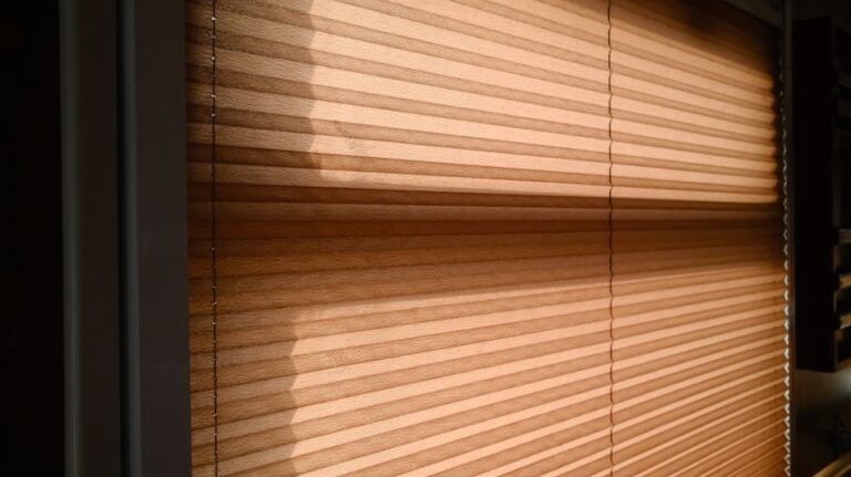 Sunlight streaming through blinds creating warm shadows in a room.