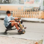 Mooncool TK1 à 1 499,99 dollars : le tricycle pliant pèse lourd Teen enjoying a ride on a colorful electric drift trike outdoors.