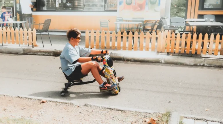Mooncool TK1 à 1 499,99 dollars : le tricycle pliant pèse lourd Teen enjoying a ride on a colorful electric drift trike outdoors.