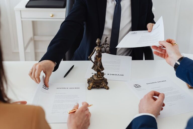 Vie privée Apple sur iPhone : une manche gagnée le 20 janvier 2026, pas le fond Three adults discussing divorce documents in a formal office setting with legal statue in view.
