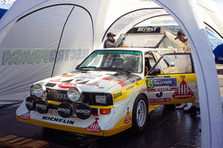Vintage Audi Quattro rally car showcased at a Portugal racing event with authentic 80s feels.