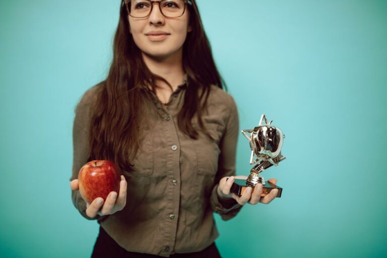 Apple TV+ obtient 7 nominations aux PGA Awards 2026, le jardin clos s’agrandit Woman holding an award trophy and apple against a turquoise background, symbolizing achievement and balance.